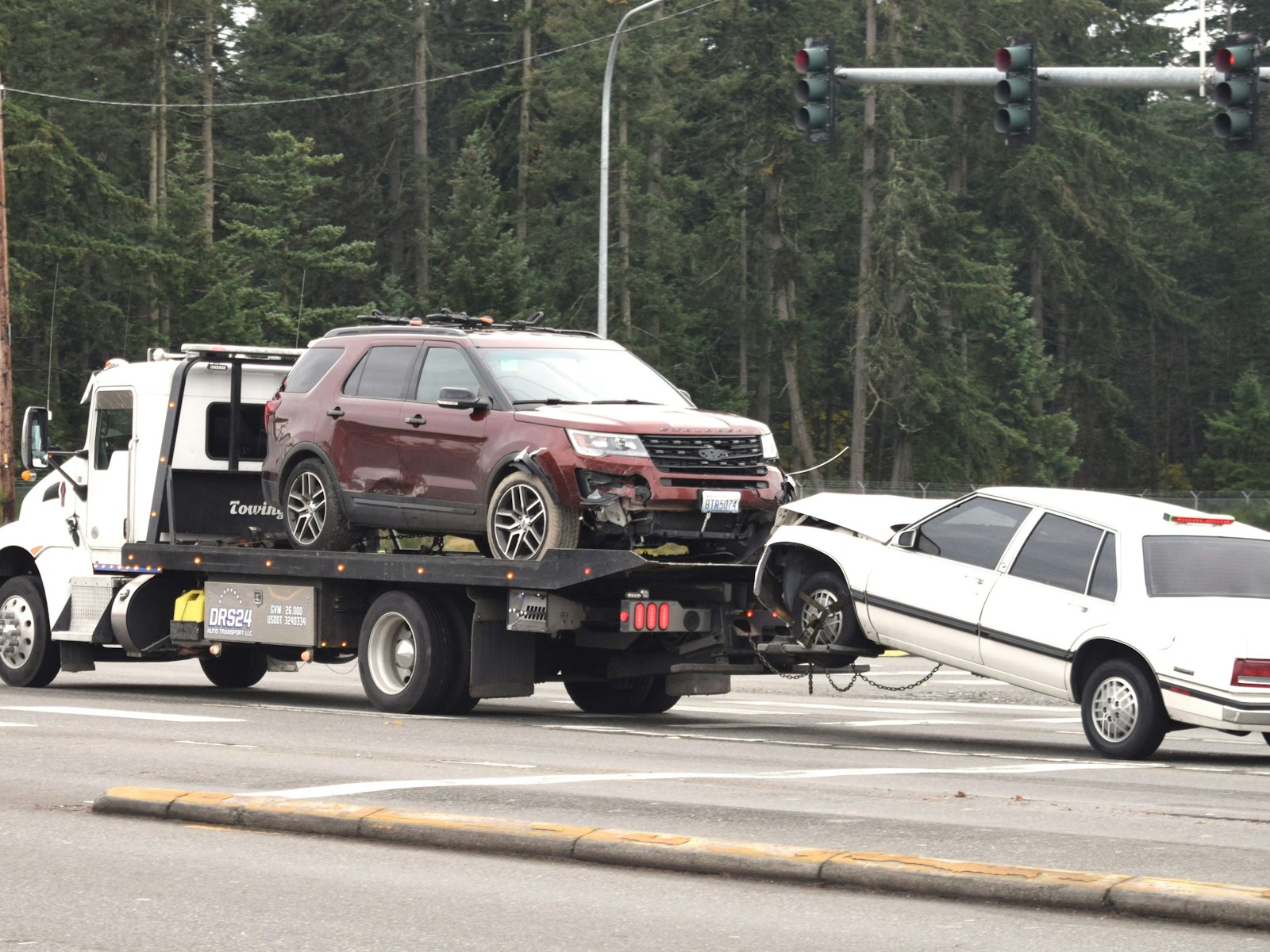 Snatch N Grab Towing flatbed tow truck loading a car on the roadside while on call
